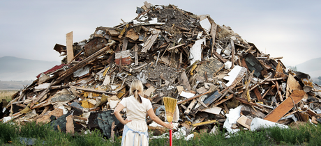 lady standing in front of large pile or garbage