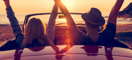 couple in car on beach at sunset